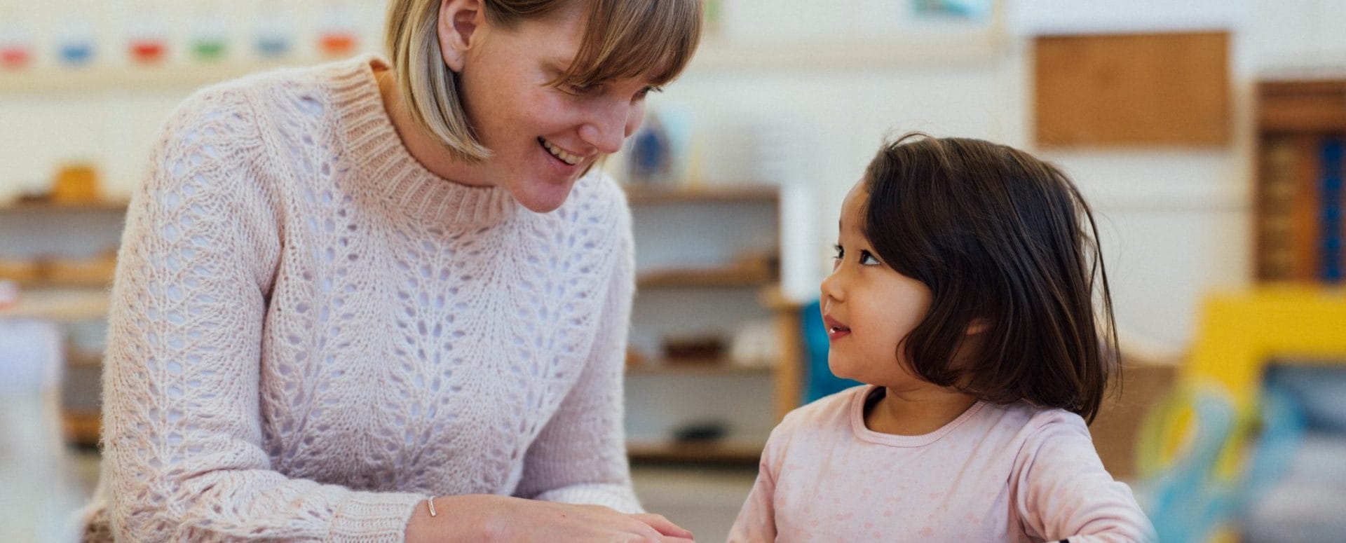AMI Montessori 3–6 diploma training – teacher guiding child with material presentation in a supportive environment with real connection